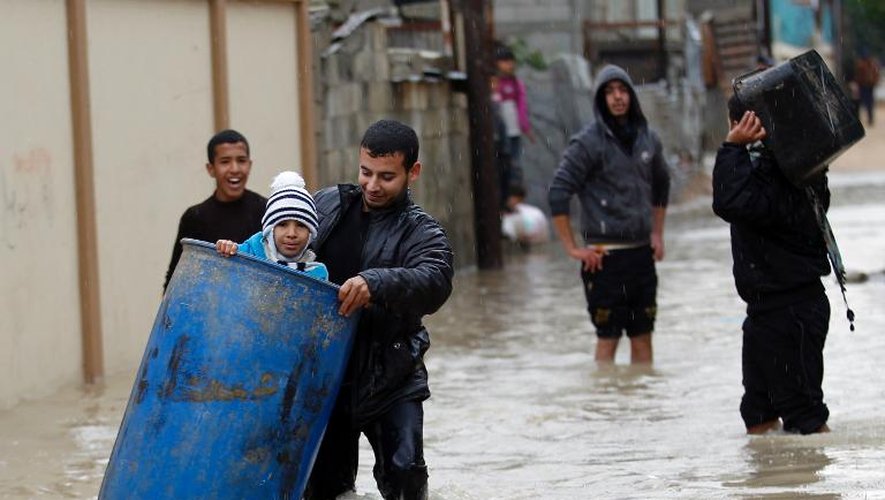 Des Palestiniens dans une rue inondée à Khan Younès le 14 décembre 2013