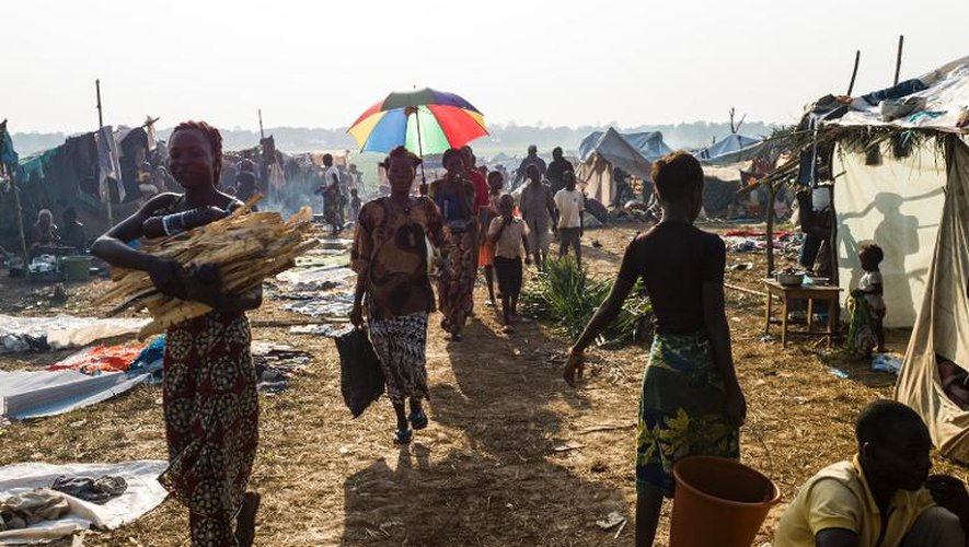 Des personnes marchent dans le camp de réfugiés de l'aéroport de Bangui le 14 décembre 2013