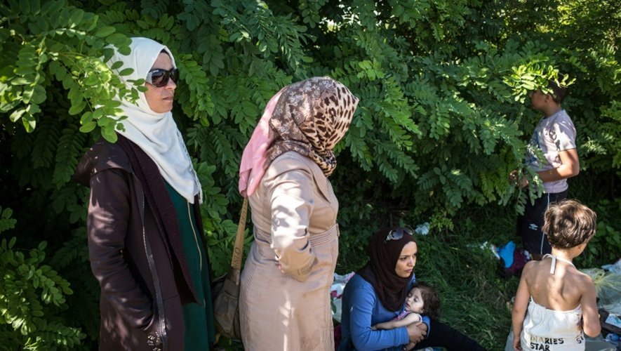 Des femmes attendent à Bapska en Croatie à la frontière avec la Serbie, le 23 septembre de monter dans des autobus pour les conduire dans un centre de transit