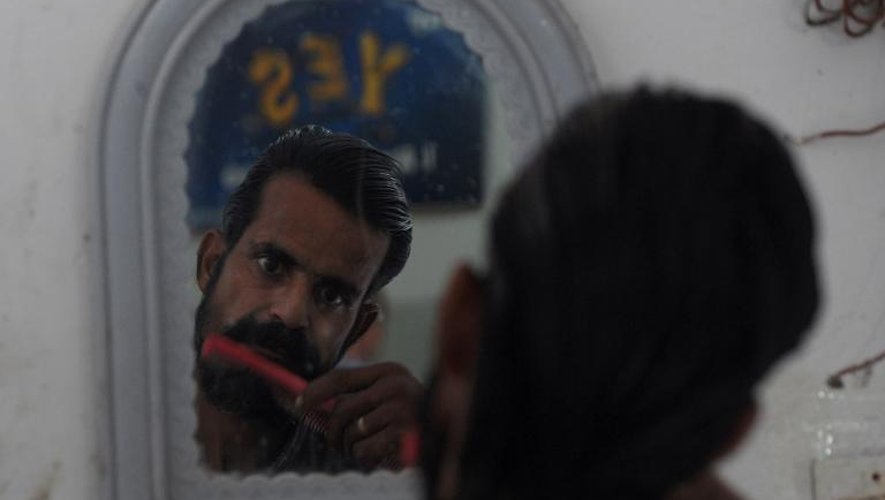 Un toxicomane pakistanais taille a barbe dans les bureaux de l'ONG Pakistan Society à Karachi le 20 novembre 2013