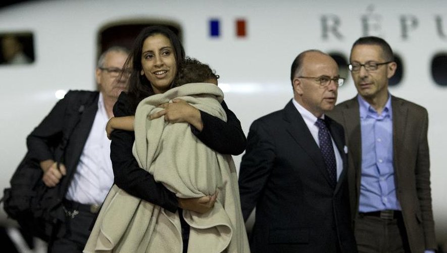 Mériam Rhaiem qui tient sa fille dans ses bras, est accueillie par le ministre de l'Intérieur à son arrivée le 3 septembre 2014 sur la base aérienne de Villacoublay
