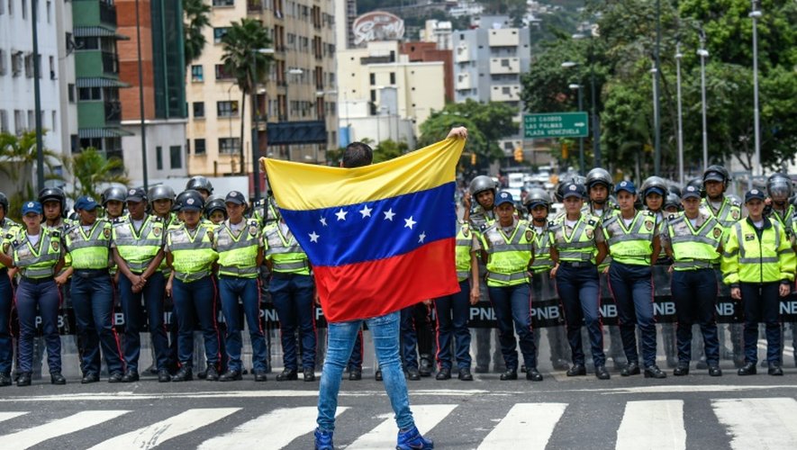 Un membre de l'opposition vénézuélienne face à un cordon policier, lors d'une manifestation à Caracas, le 27 juillet 2016