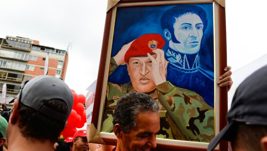 Des sympathisants du président vénézuélien Nicolas Maduro exhibent un portrait de l'ancien chef de l'Etat Hugo Chavez à Caracas le 22 juin 2016
