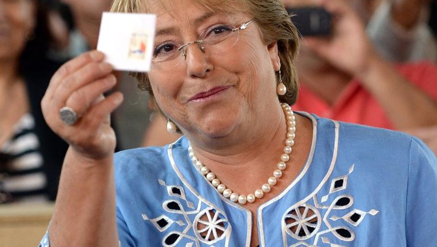 L'ex-présidente socialiste du Chili Michelle Bachelet montre son bulletin de vote pour la présidentielle le 15 décembre 2013 à Santiago