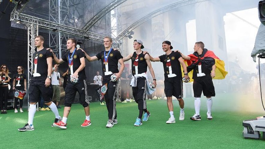 Les champions allemands (de gauche à droite): Manuel Neuer, Kevin Grosskreutz, Matthias Ginter, Julian Draxler, Benedikt Hoewedes et Bastian Schweinsteiger, fêtés par leur public, le 15 juillet 2014 Porte de Brandebourg