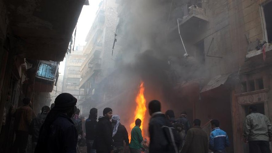 Des Syriens regardent les dégâts causés par des raids de l'armée, le 15 décembre 2013 à Alep