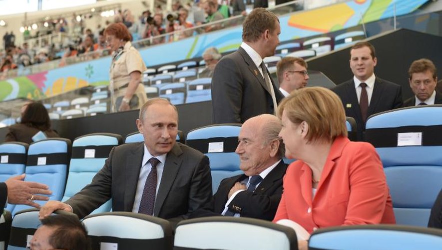 Le président russe Vladimir Poutine (g) discute avec Joseph Blatter et la Cancelière Angela Merkel (d) lors de la finale de la Coupe du monde à Rio de Janeiro, le 13 juillet 2014