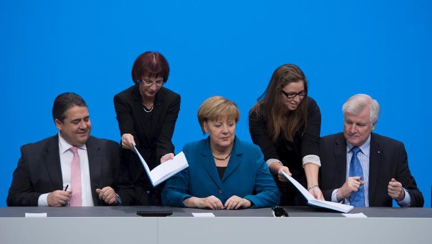 La chancelière Angela Merkel (c) entourée de Sigmar Gabriel (g) et Horst Seehofer, le 16 décembre 2013 à Berlin
