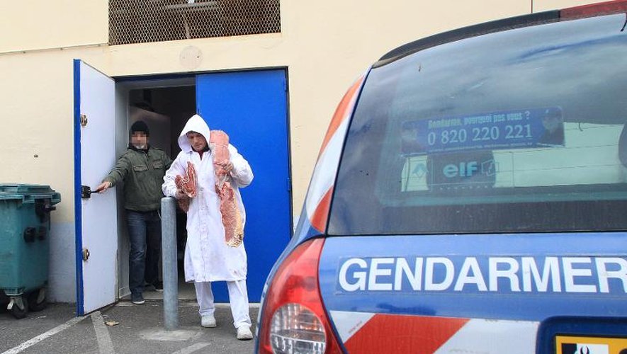 Un employé d'un dépôt de boucherie à Narbonne le 16 décembre 2013, sous surveillance de la police