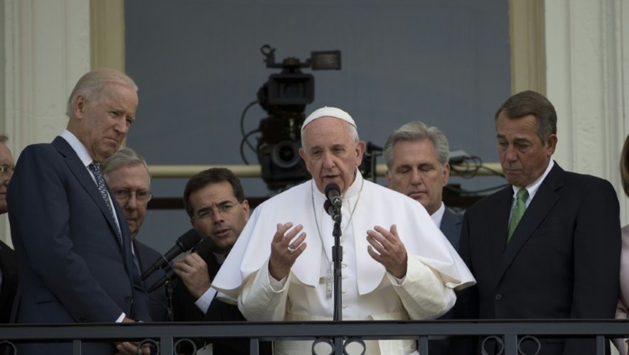 Le pape François prient face à la foule depuis le balcon du Capitole à Washington, le 24 septembre 2015, aux côtés du vice-président Joe Biden (g)
