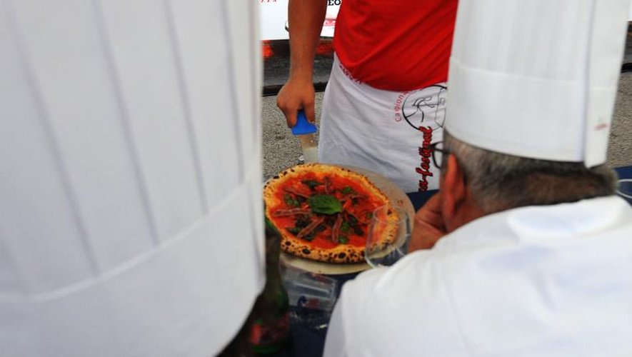 Des membres du jury des championnats du monde de pizza, qui se déroulent à Naples le 3 septembre 2014, scrutent attentivement le travail d'un candidat