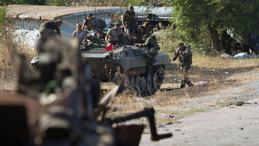 Des séparatistes prorusses assis sur un char sur une route près du village de Novokaterinovka, à 50 km au sud-est de Donetsk, dans l'est de l'Ukraine