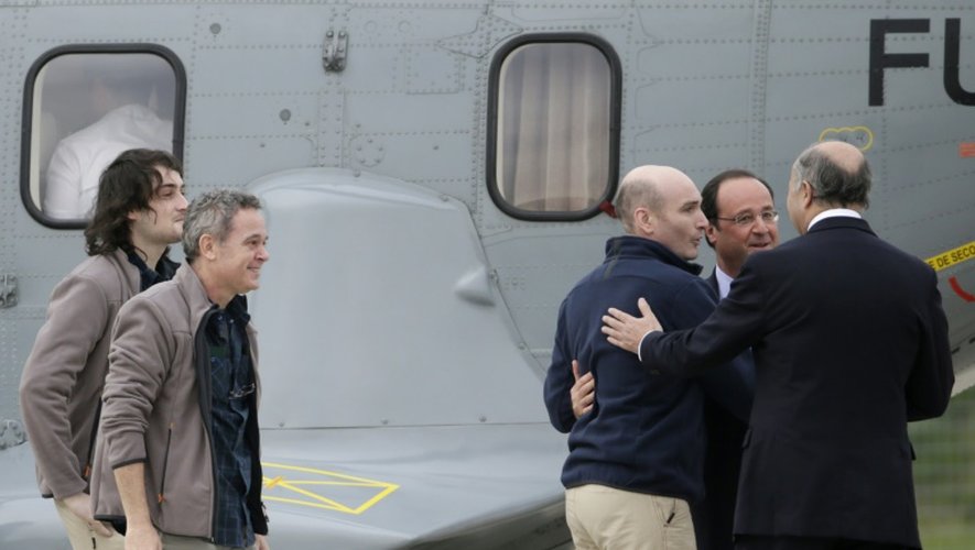 Edouard Elias, Didier François, Nicolas Hénin accueillis par François Hollande et Laurent Fabius à leur arrivée le 20 avril 2015 à Villacoublay après leur libération
