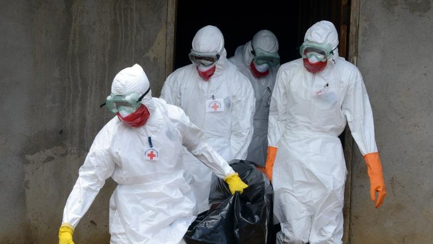 Des personnels médicaux de la Croix-Rouge libérienne, vêtus de combinaison de protection, évacuent le corps d'une victime du virus Ebola, le 4 septembre 2014 à Banjol, à 30 km de Monrovia