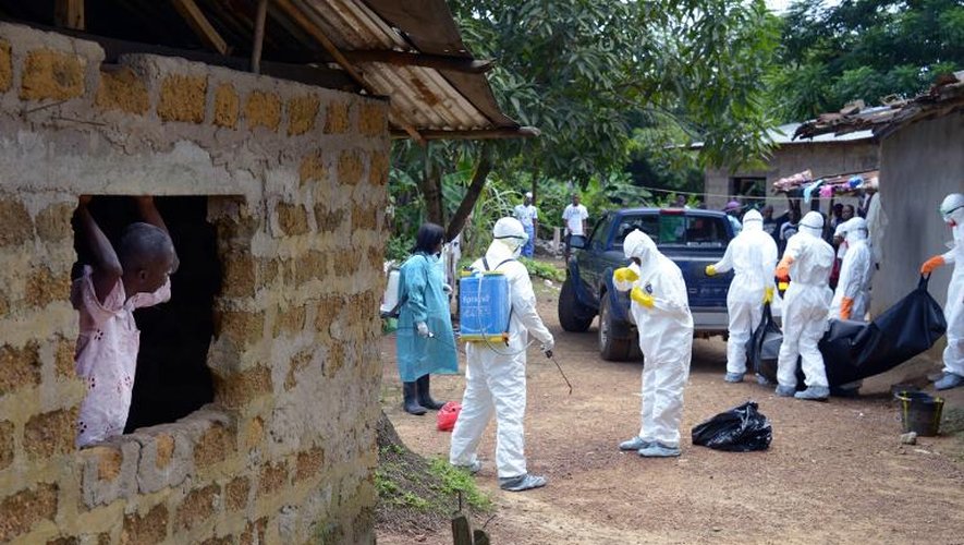 Des personnels médicaux de la Croix-Rouge libérienne, vêtus de combinaison de protection, évacuent le corps d'une victime du virus Ebola, le 4 septembre 2014 à Banjol, à 30 km de Monrovia