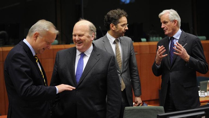 Le commissaire européen aux affaires économiques et monétaires Olli Rehn (gauche) discute avec le ministre irlandais Michael Noonan, et le ministre néerlandais Jeroen Dijsselbloem discute avec Michel Barnier le 17 décembre 2013 à Bruxell