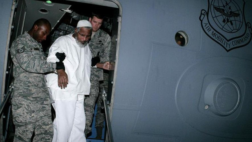 Des soldats américains aident le prisonnier soudanais Ibrahim Othman Ibrahim Idris à sortir de l'avion à Khartoum le 19 décembre 2013