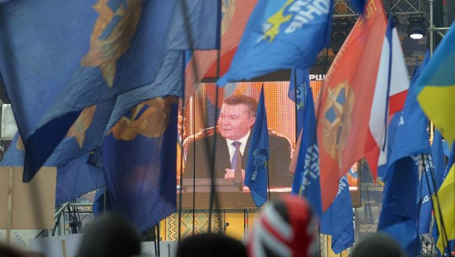 Des partisans du président ukrainien Viktor Ianoukovitch regardent la retransmission de sa conférence de presse à Kiev le 19 décembre 2013