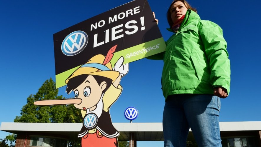 Une militante de Greenpeace manifeste devant le site de Volkswagen avec une pancarte représentant Pinocchio et réclamant la fin des mensonges, le 25 septembre 2015 à Wolfsburg