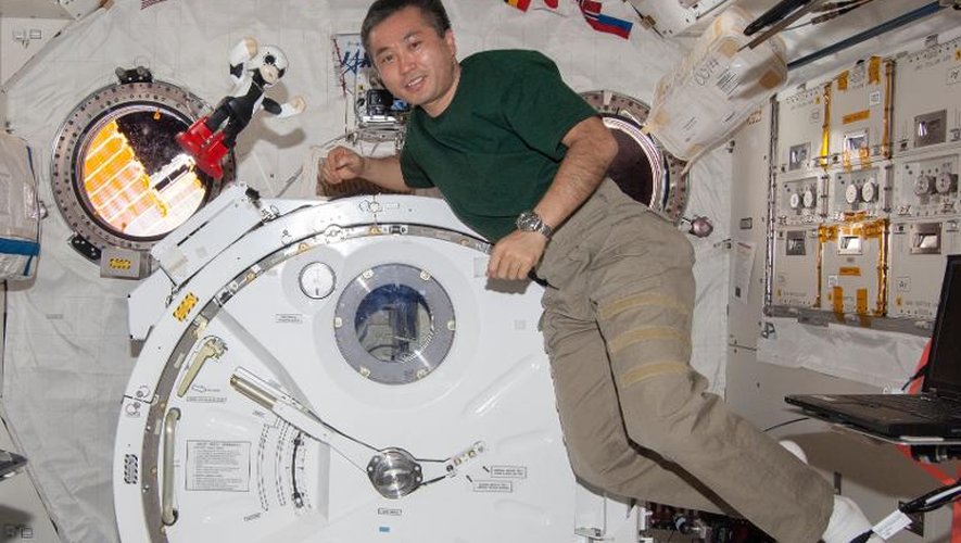Photo diffusée le 20 décembre 2013 par le Projet Kibo Robot montrant l'astronaute Koichi Wakata (d) flottant dans la Station spatiale internationale (ISS) avec le petit robot Kirobo