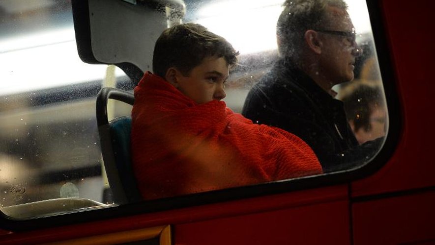 Des personnes blessées assises dans un bus après l'effondrement du toit du théâtre à Londres le 19 décembre 2013