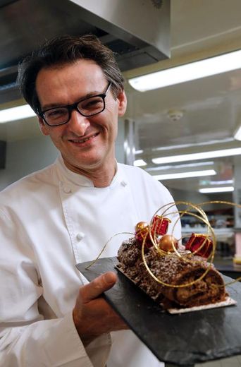 Laurent Jeannin montre la bûche chocolat-noix de pécan caramélisées qu'il vient de faire le 26 novembre 2013 à Paris