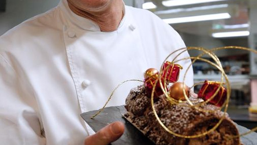 Laurent Jeannin montre la bûche chocolat-noix de pécan caramélisées qu'il vient de faire le 26 novembre 2013 à Paris