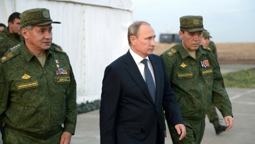 Le président russe Vladimir Poutine assiste à un exercice militaire avec le ministre de la Défense Sergei Shoigu (G) ainsi que le chef d'état major des armées Col.Gen.Valery Gerasimov (D) dans la région d'Orenbourg, le 19 septembre 2015