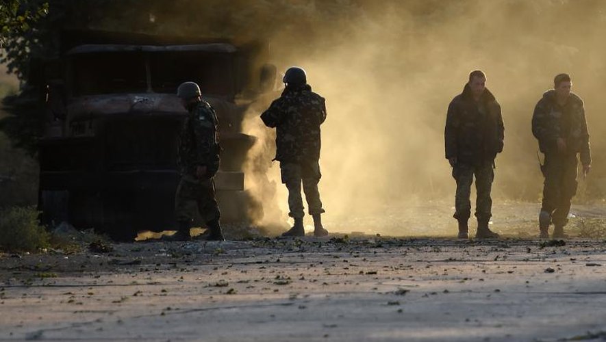 Des soldats ukrainiens autour d'un char incendié le 7 septembre 2014 à Marioupol