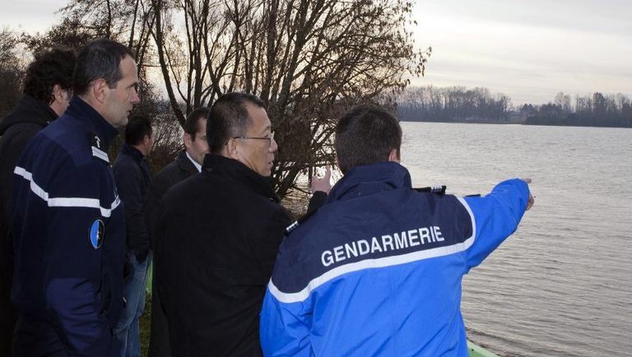 Un officiel chinois parle avec des gendarmes de l'équipe de secours, le 21 décembre 2013 à Lugon-et-l'Ile-du-Carnay