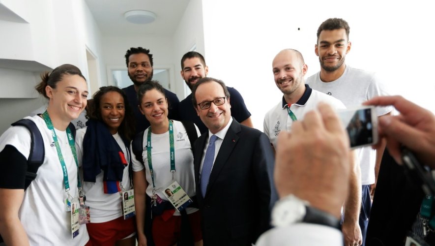 Le président français François Hollande pose en compagnie de membres des équipes françaises de hand-ball masculine et féminine lors d'une visite du village olympique à Rio de Janeiro, le 4 août 2016