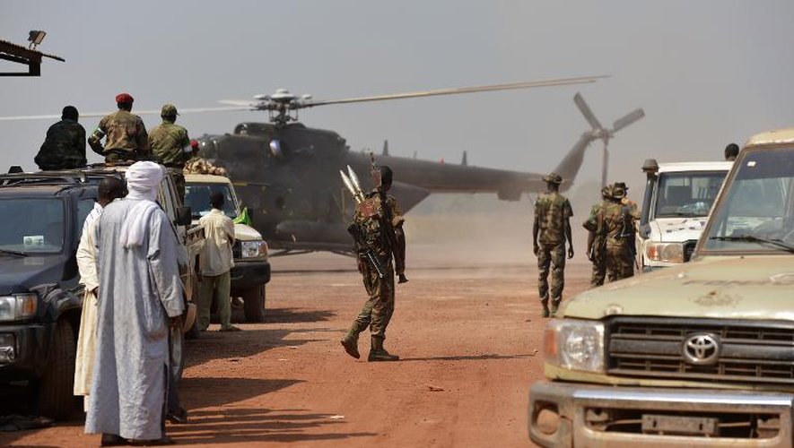 Des civils et des soldats tchadiens regardent un hélicoptère atterrir sur l'aéroport de Bangui le 21 décembre 2013