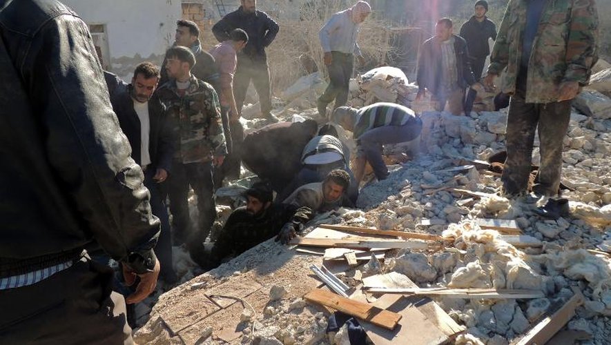 Des Syriens cherchent des survivants de raids aériens, à Alep le 22 décembre 2013