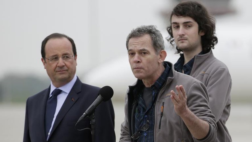 L'ex-otage Didier Francois entre François Hollande et un autre ex-otage Edouard Elias, à leur arrivée le 20 avril 2014 à l'aéroport de Villacouoblay