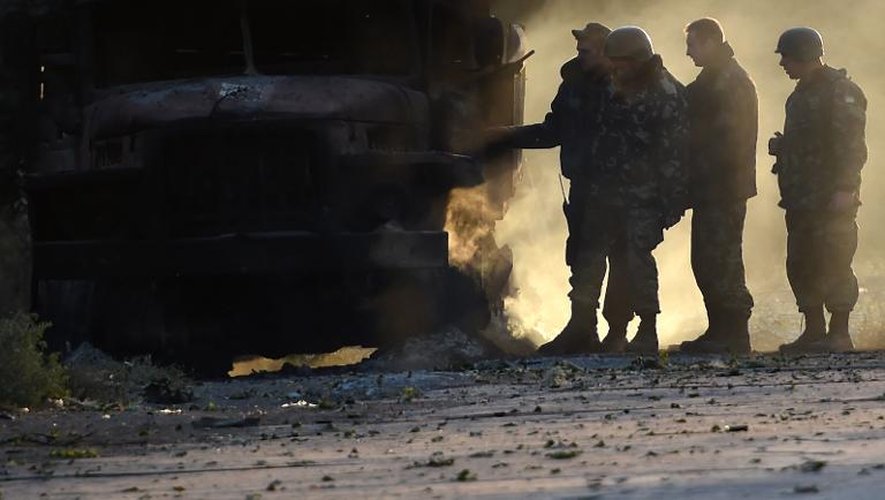 Des soldats ukrainiens près d'un camion incendié lors de combats nocturnes contre les séparatistes prorusses, le 7 septembre 2014 dans les environs de Marioupol