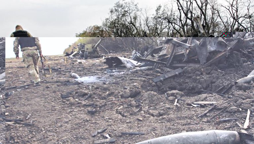 Un combattant ukranien passe devant des restes de matériels militaires détruits dans des affrontements avec les séparatistes prorusses, à 20 km au nord-est de Marioupol