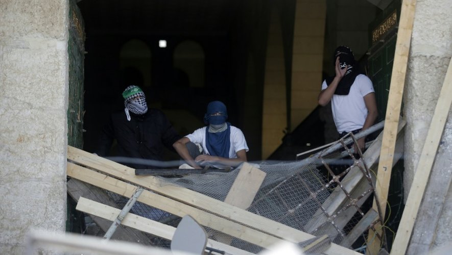 Des Palestiniens masqués barricadés à l'intérieur de la mosquée le 27 septembre 2015 à Jérusalem