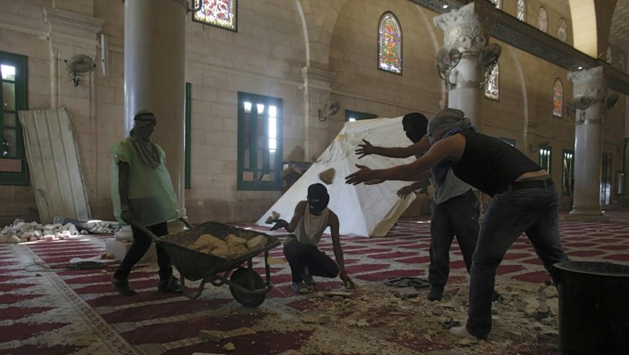 Des Palestiniens masqués cassent des pierres à l'intérieur de la mosquée le 27 septembre 2015 à Jérusalem