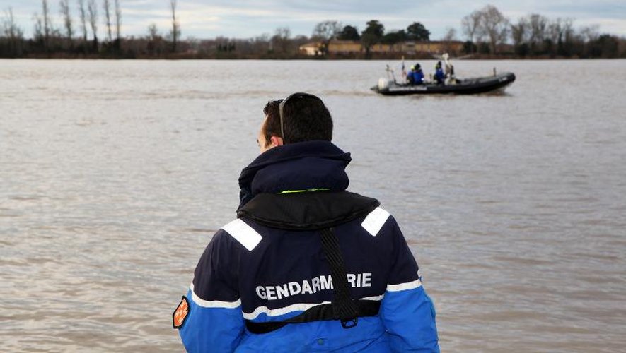 Des gendarmes scrutent la Dordogne le 22 décembre 2013 à Lugon-et-l'Ile du Carnay, à la recherche de l'hélicoptère qui s'y est abîmé