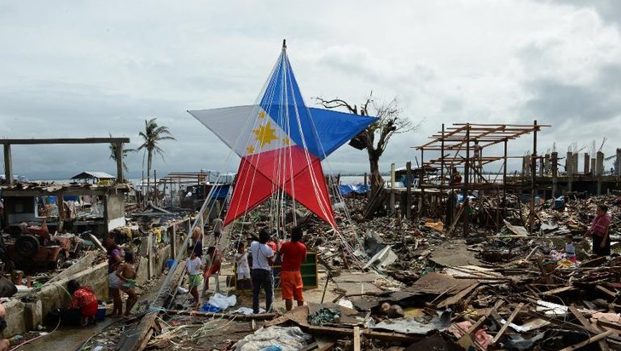 Des rescapés du typhon Haiyan décorent une lanterne géante pour Noël au milieu des ruines à Tacloban le 24 décembre 2013