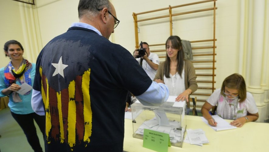 Un homme met un bulletin dans l'urne à Barcelone le 27 septembre 2015 à Barcelone