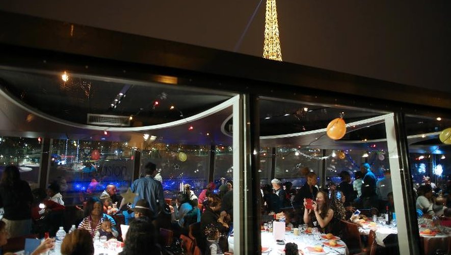 Des personnes participent à un dîner de Noël organisé par le Secours catholique sur une péniche à Paris, le 24 décembre 2013