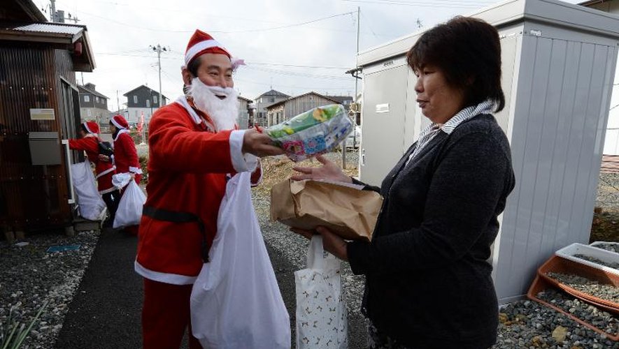 Des bénévoles costumés en Père Noël distribuent des cadeaux le 21 décembre 2013 aux habitants d'Iwaki dans la région de Fukushima