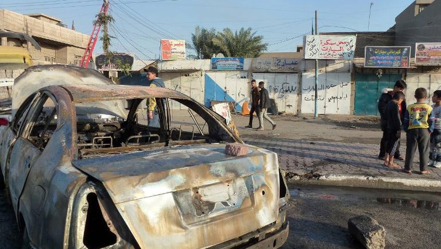 Une carcasse de voiture après un attentat à la voiture piégée dans un quartier chiite de l'ouest de Bagdad, le 3 décembre 2013