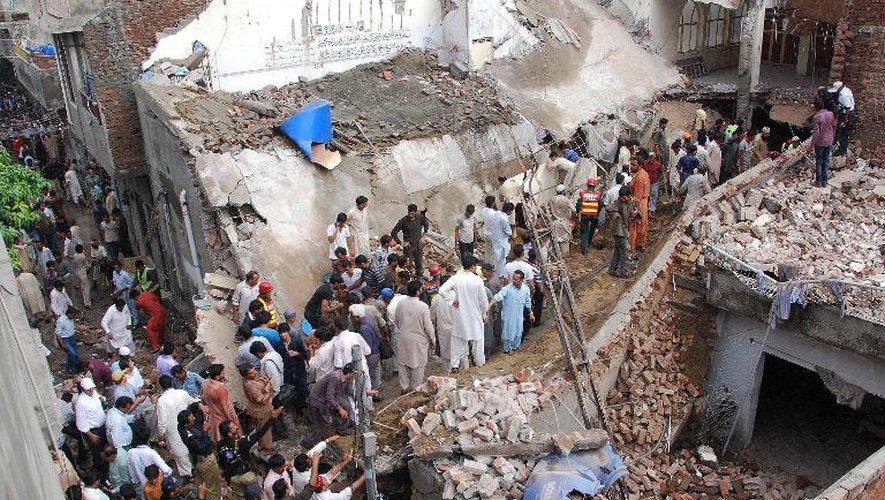 Des secouristes pakistanais et des habitants recherchent des survivants dans les décombres d'une mosquée qui s'est effondrée, le 10 septembre 2014 à Lahore