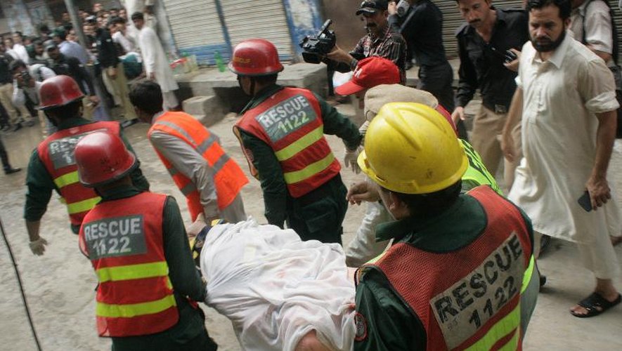 Des secouristes évacuent le corps d'une victime après l'effondrement d'une mosquée, le 10 septembre 2014 à Lahore