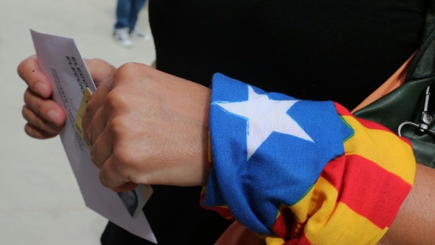 Une femme, un foulard indépendantiste au poignet, dans un bureau de vote de Badalona en Espagne, le 27 septembre 2015
