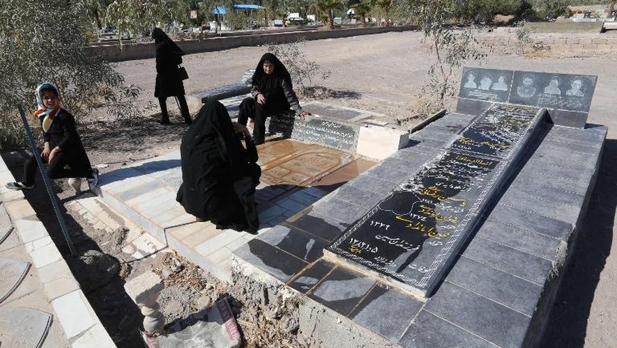 Une famille iranienne prie sur la tombe d'un proche mort dans le séisme de Bam, le 19 décembre 2013