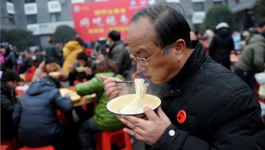 Un homme mange un bol de nouilles traditionnelles, offert aux Chinois à l'occasion du 120e anniversaire de la naissance de Mao Tsa-toung le 26 décembre 2013 à Shaoshan, sa ville natale