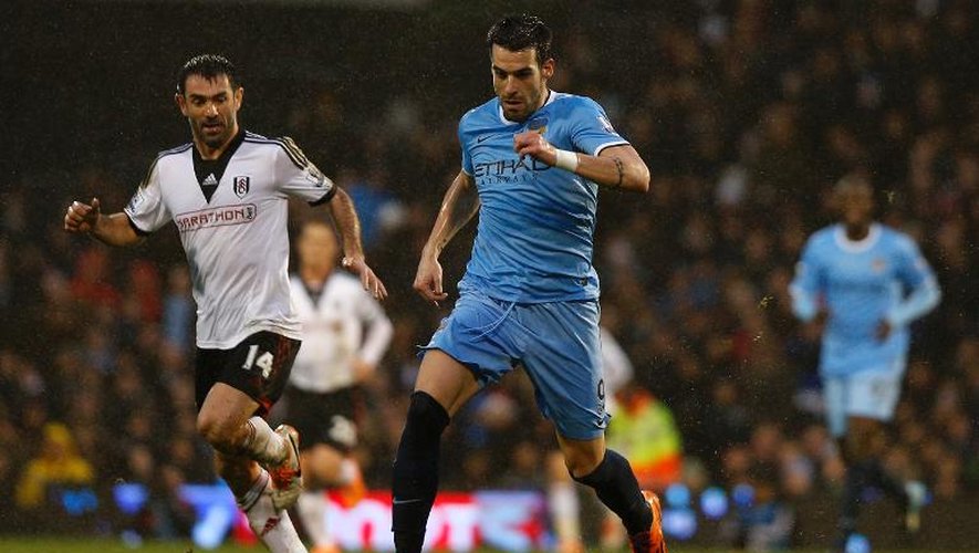 L'attaquant espagnol de Manchester City Alvaro Negredo (d) échappe au milieu grec de Fulham Giorgos Karagounis en championnat d'Angleterre, le 21 décembre 2013